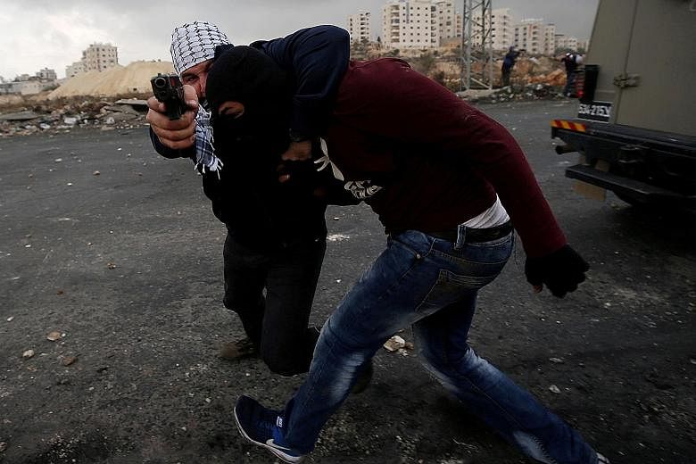 An undercover Israeli security officer detaining a Palestinian during clashes at a rally yesterday against the US decision on Jerusalem, near the Jewish settlement of Beit El, close to Ramallah in the West Bank.