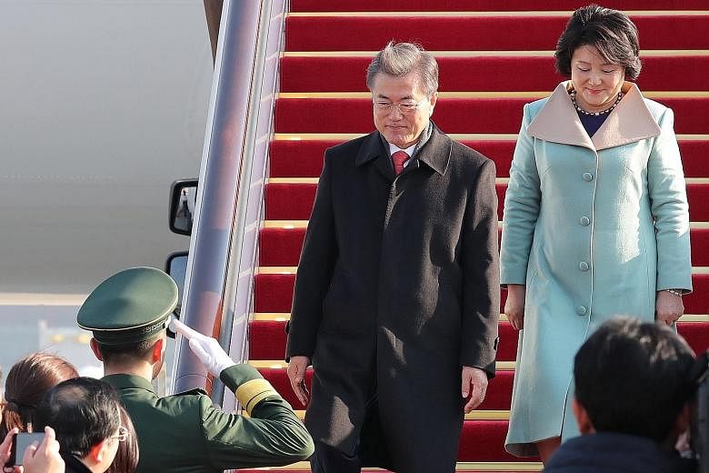 South Korean President Moon Jae In and his wife Kim Jung Sook arriving in Beijing yesterday. Mr Moon will hold a bilateral summit with President Xi Jinping, attend business forums and travel to Chongqing over four days.