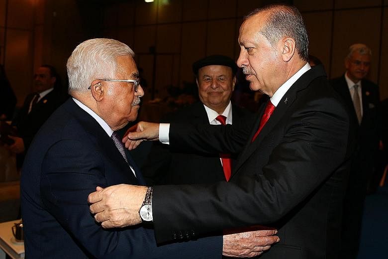 Turkish President Recep Tayyip Erdogan (far right) greeting Palestinian President Mahmoud Abbas yesterday during the OIC summit in Istanbul. In a communique, the OIC said the US decision on Jerusalem was "null and void legally", and "a deliberate und