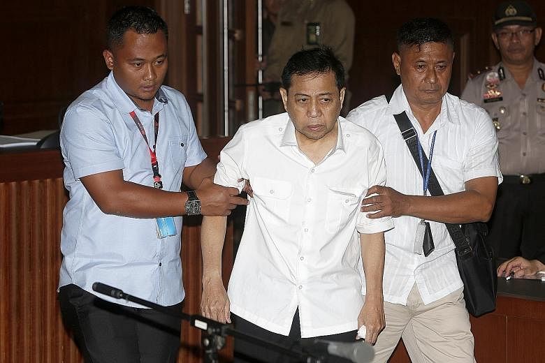Setya Novanto being escorted by Corruption Eradication Commission officers during his first trial at the Central Jakarta district court yesterday. Doctors found him fit to stand trial, but he refused to answer questions and confirm details like his n