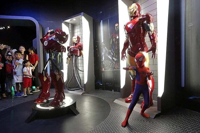 Leroy Teo, eight, dressed as Spider-Man, poses next to Iron Man at the Marvel exhibits at Madame Tussauds Singapore on Sentosa.