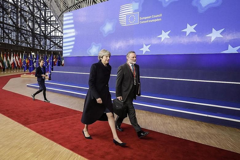 Britain's Prime Minister Theresa May and UK Permanent Representative to the European Union Tim Barrow arriving for the first day of an EU summit in Brussels on Thursday. The bloc agreed yesterday to move talks forward with London.