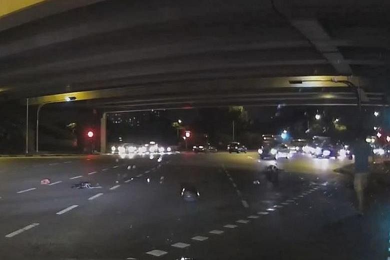 A video screengrab showing a passer-by (right), who wanted to be known only as Mr Ng, rushing to help after motorcyclist Jonathan Choy was injured in a hit-and-run accident.