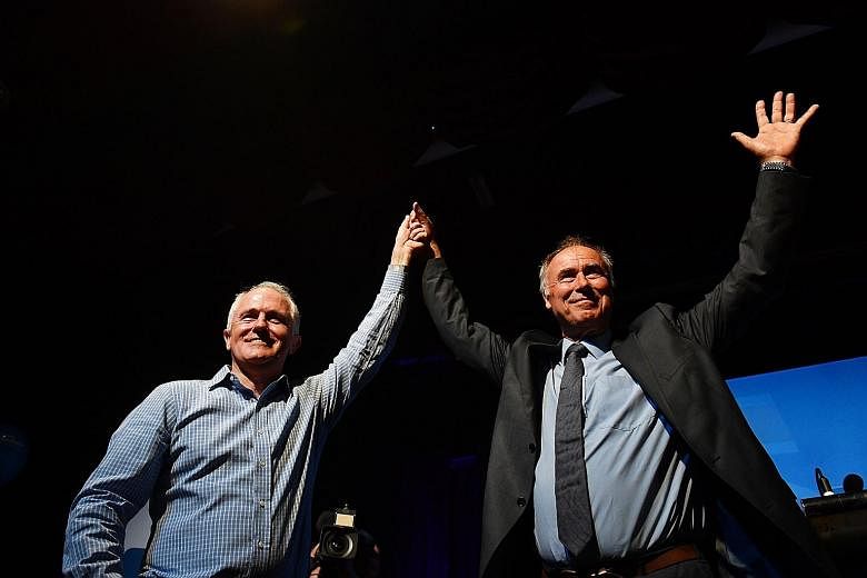 Australian Prime Minister Malcolm Turnbull (left) and newly elected Liberal member for Bennelong John Alexander celebrating at the by-election night party at the West Ryde Leagues Club in Sydney, New South Wales, Australia, yesterday.