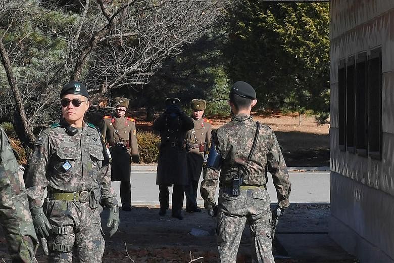 North and South Korean soldiers at the truce village of Panmunjom. The North Korean defector who made a dash last month was shot while fleeing across the border.