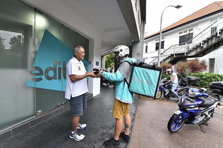 New Ubin Seafood co-founder Pang Seng Meng with a Deliveroo rider. The meats and rice bowl dishes are quick to prepare and suitable for delivery, offering access to a new market without alienating the eatery's existing customer base, said Mr Pang.
