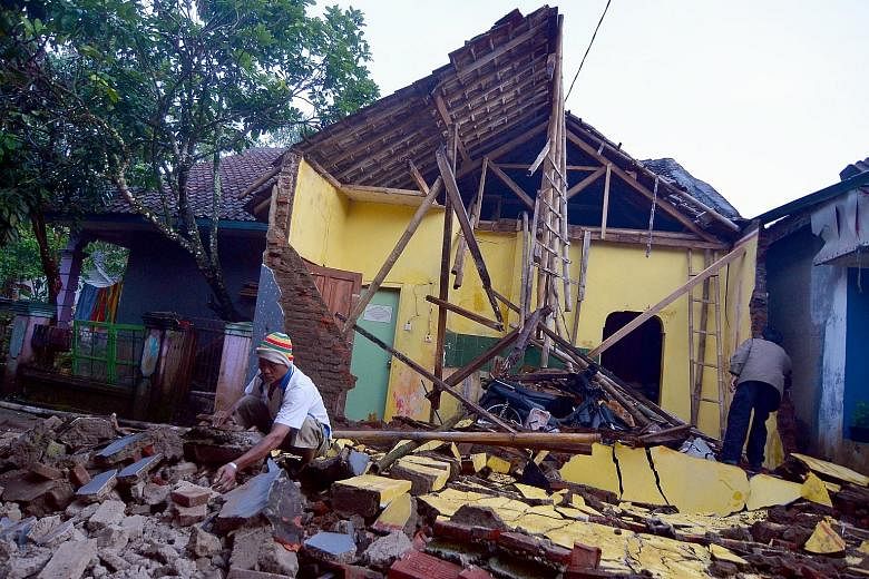 Left: A man going through the rubble of his collapsed house yesterday after a 6.5-magnitude earthquake hit Sumelap Village in Tasikmalaya, West Java, just before midnight on Friday. Below: Patients in Banyumas' regional public hospital in Central Jav