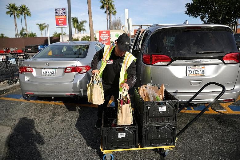 An employee from a Ralph supermarket in Los Angeles serving a customer who had ordered his groceries online and reserved a pickup time in advance.