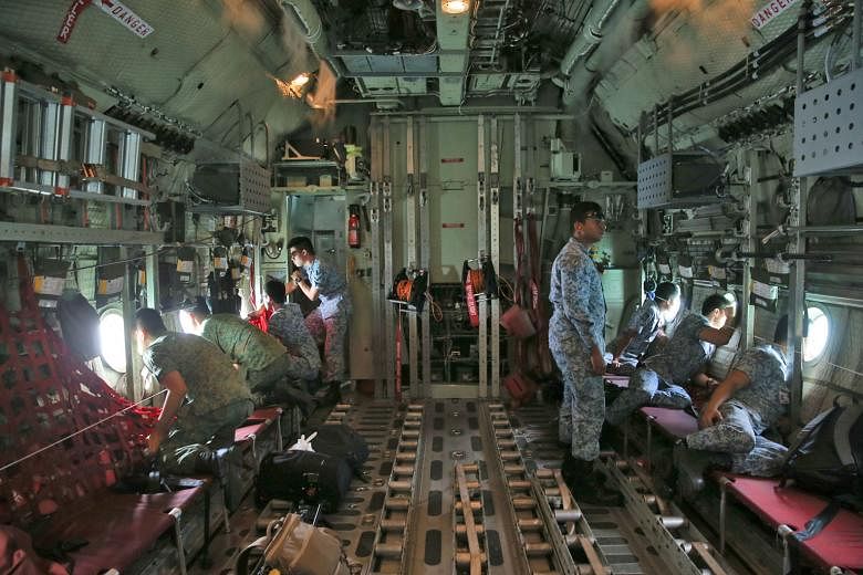 Republic of Singapore Air Force personnel on board a C-130, scanning the sea for the 10 missing sailors as the plane flew over the search area on Aug 23. The USS John S. McCain was left with a vast hole in its hull, after being involved in a collisio