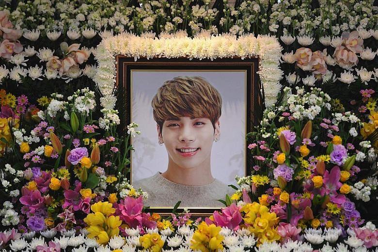 A memorial for popular K-pop star Jonghyun (above) at Seoul's Asan Medical Centre. Hundreds of fans (left) have turned up at the memorial hall and some were seen wailing uncontrollably.