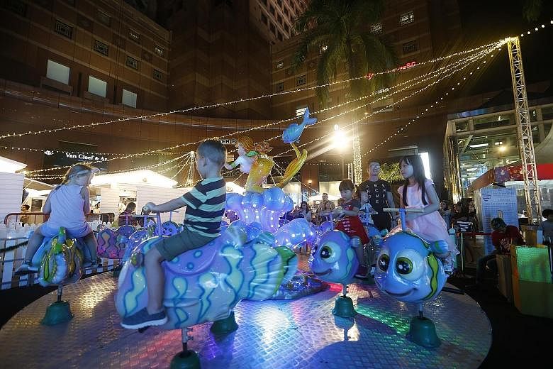 Kids having fun yesterday on board the Ocean's Ride at the Christmas Village at Ngee Ann City's Civic Plaza. The month-long event, which started on Nov 25, features outdoor shopping, dining and nightly performances, with 25 brands having set up shop 