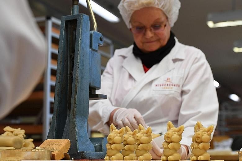 An employee of traditional confectionery maker JG Niederegger preparing pigs made of fresh marzipan in Luebeck, Germany. For Germans, no Christmas is complete without marzipan, the sugar and almond treat that dates back to the Middle Ages. Market pre