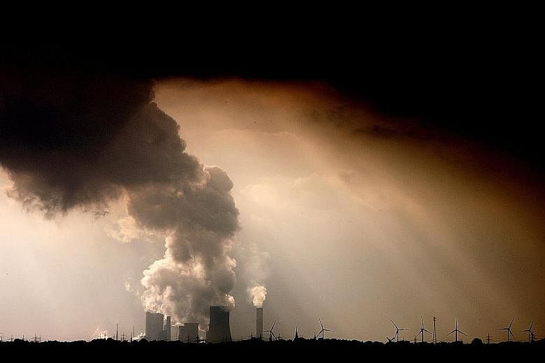 Smoke and vapour rising from the cooling towers and chimneys of a power plant near Bergheim in Germany in 2009. The KPMG survey found that only 17 per cent of Singapore firms have set carbon reduction targets, which pales in comparison to the global 
