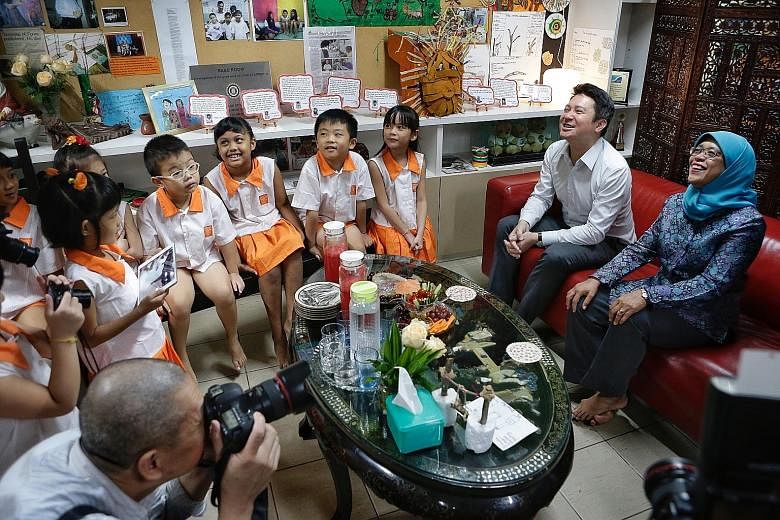 President Halimah Yacob sharing a light moment with Child At Street 11 pupils (seated from left) Matthew Lim, Cassara Chen (both partially blocked), Ryan Lim, Aryssha Balqis Abdullah, Lucas Yeo and Kelly Ong, whose stories are in the book Sayang. Tch