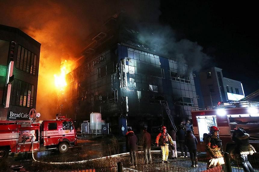 Television footage showed the building consumed by orange flames and issuing dark plumes of smoke. Some people were seen jumping from the building onto air mattresses laid out on the ground.