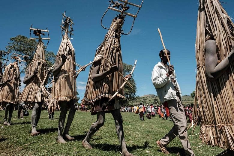 Circumcised Maasai young men in ritual costumes adorned with birds they hunted emerging from the bush near Kilgoris, Kenya, on Wednesday to receive blessings to mark the end of the annual month-long circumcision ceremony. As a rite of passage, the 18