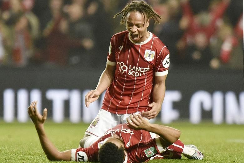 Bobby Reid celebrating Bristol's win with team-mate Korey Smith (on ground), who scored the winner. Bristol's reward is a semi-final against Premier League leaders Manchester City.