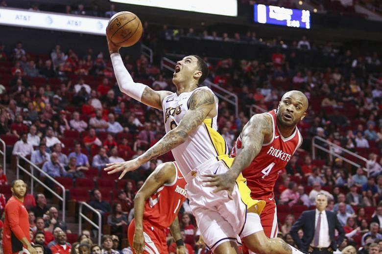 Los Angeles Lakers forward Kyle Kuzma evading the attention of Houston Rockets forward PJ Tucker as he goes for a lay-up during the Lakers' upset victory over the Rockets. Rookie Kuzma contributed 38 points to the Lakers' cause, as they halted the We