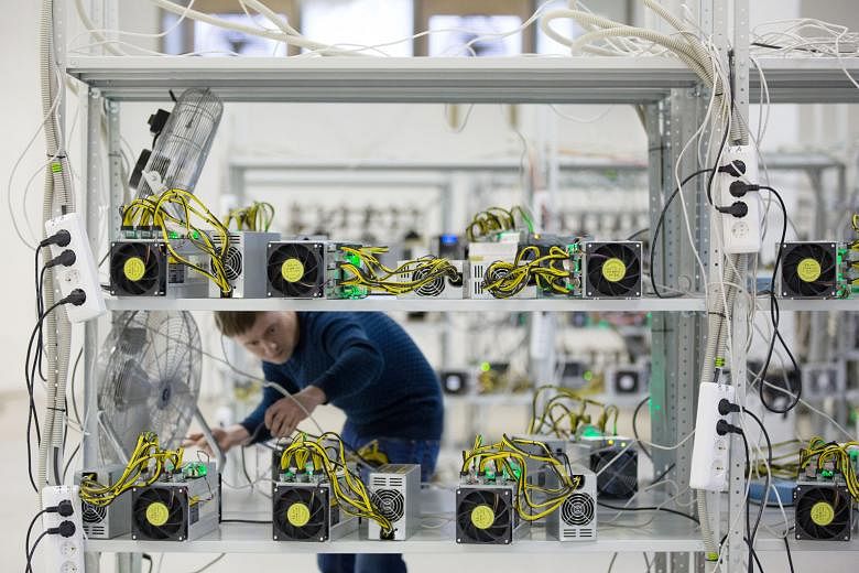 An employee checking power supply units and cooling fans used in cryptocurrency mining machine systems at the SberBit mining "hotel" in Moscow. According to one projection by Digiconomist, more energy will be exhausted by bitcoins than the whole of t