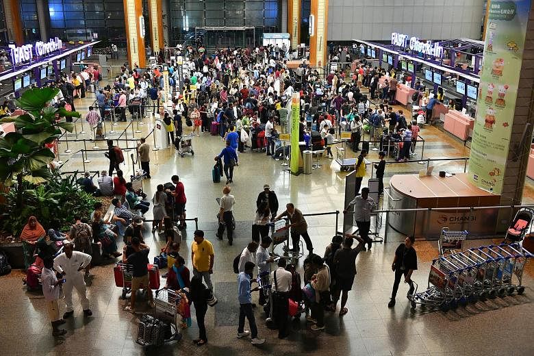 The crowd at Changi Airport Terminal 2's departure hall last Saturday. Industry players say more Singaporeans are travelling overseas this year-end, compared with the same period last year.