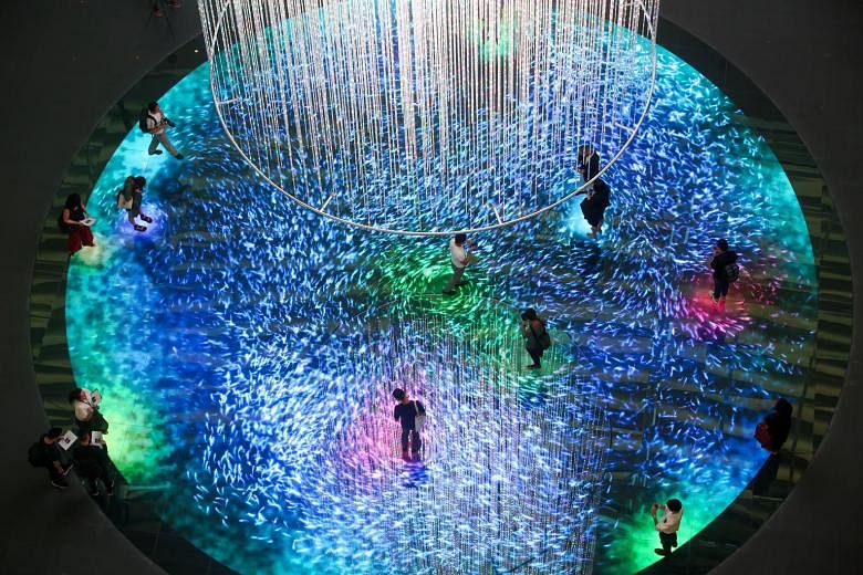 Digital Light Canvas has a 14m-tall light installation hanging from the ceiling, above a circular floor embedded with LED lights. Visitors can pay to walk on the LED floor, which renders graphics.