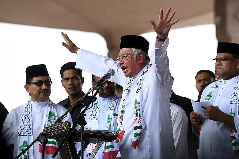 Malaysian Prime Minister Najib Razak speaking at the rally in Putrajaya yesterday. The gathering was to mark the second time PM Najib and opposition politician Abdul Hadi Awang were to share the same stage at a political rally, but the latter did not