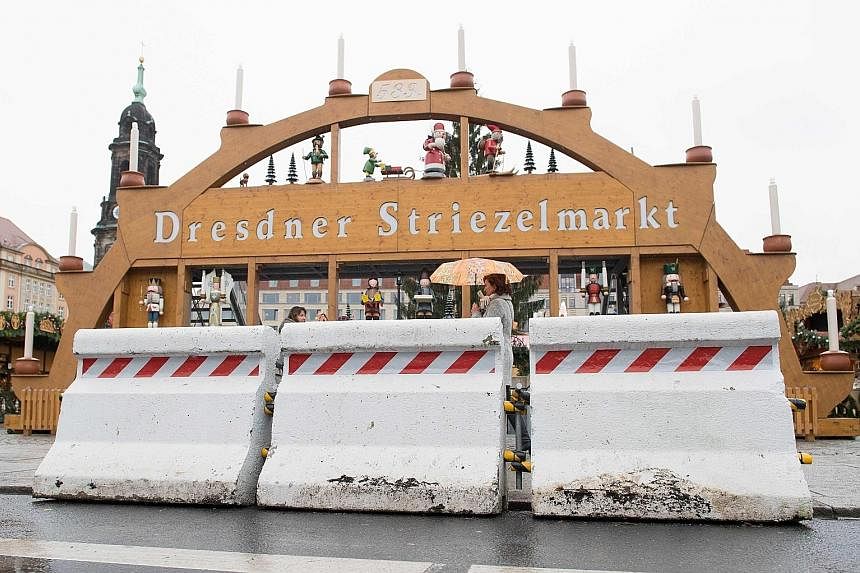 Concrete security barriers in front of a giant decoration of the Christmas market in Dresden.