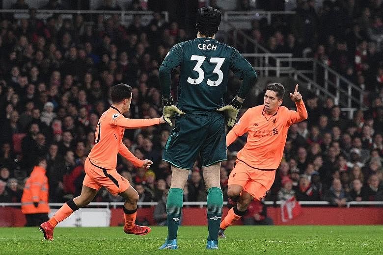 Liverpool forward Roberto Firmino (right) celebrating with team-mate Philippe Coutinho after equalising for their third goal against Arsenal at the Emirates Stadium on Friday. The Reds could not take their chances in the first half despite controllin
