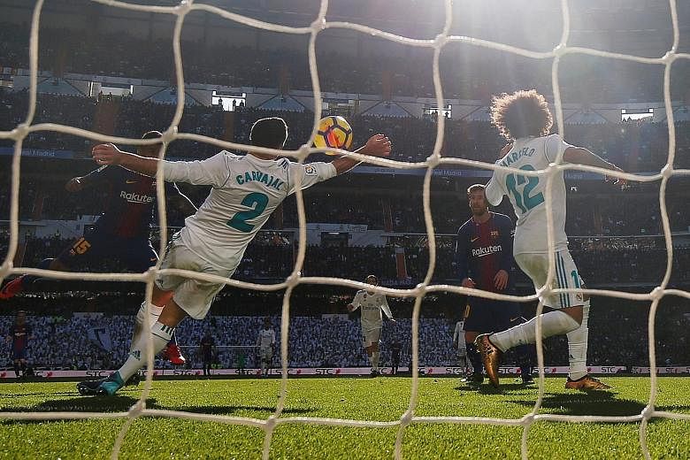 Left: Barcelona forward Luis Suarez celebrating after opening the scoring in the 54th minute in the Clasico against Real Madrid at the Santiago Bernabeu yesterday. Below: Real Madrid right-back Dani Carvajal handling the ball in the box in the 63rd m