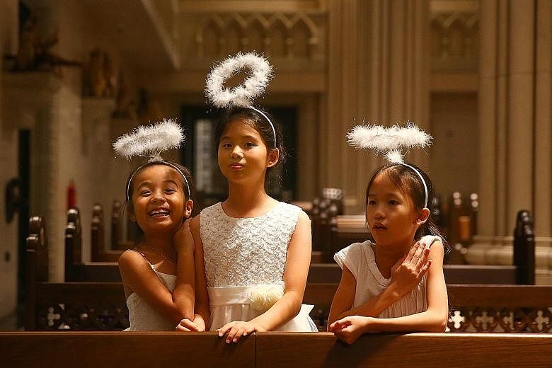 Little "angels" (from left) Megan Lim, seven, Jerlene Lim, 10, and Megan Wong, eight, getting ready for the rehearsal. Mr Jeffrey Foo and Ms Kaitlyn Quek, acting as Joseph and Mary for Novena Church's nativity play, during the final rehearsal last Fr