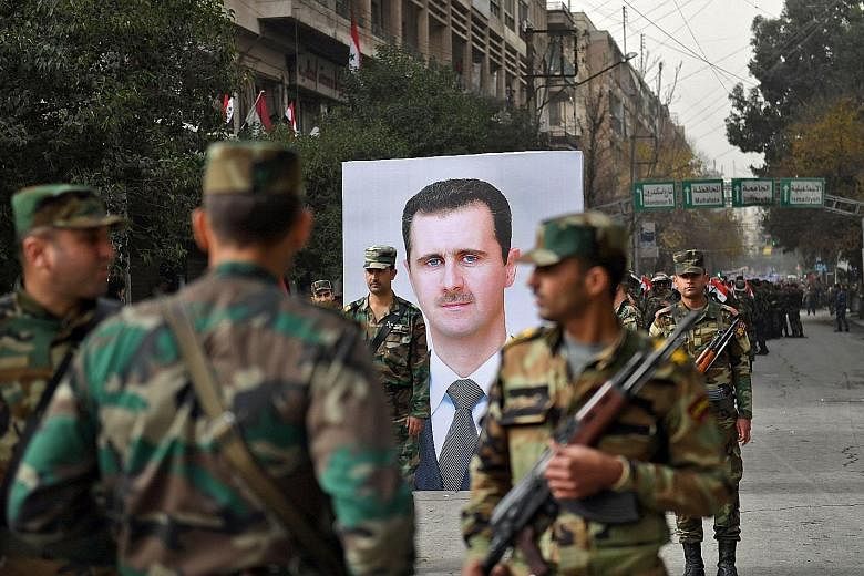 Syrian soldiers walking past a portrait of President Bashar al-Assad. One obstacle for Chinese firms in Syria is that settlements in dollars and euros are banned because of US and EU sanctions aimed at cutting Mr Assad's regime off from the world eco