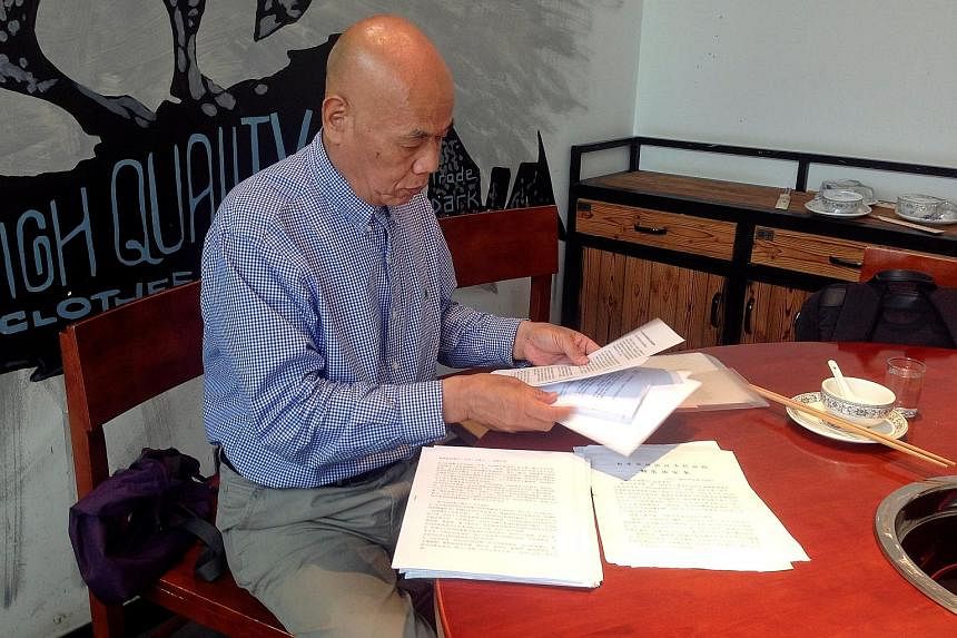 Mr Xu Xiaoshun (left) reading through documents on the case against his son Wu Gan (above) in June. Wu, who went by the online name "Super Vulgar Butcher", made public shaming of China's officials a raucous art form.