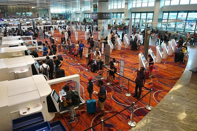 Above and left: A group of 30 check-in kiosks and 20 baggage drop-off machines in the centre of the departure hall at Changi Airport's Terminal 1. More self-service counters have been unveiled at the terminal in an effort to boost efficiency and redu