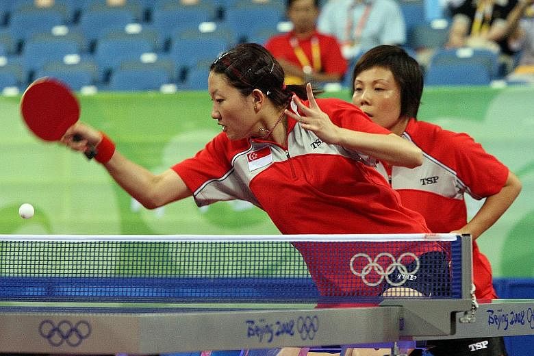 Li Jiawei (front) and Wang Yuegu on the way to winning their match to help Singapore to a 3-2 victory over South Korea in the semi-finals of the Beijing Olympics.
