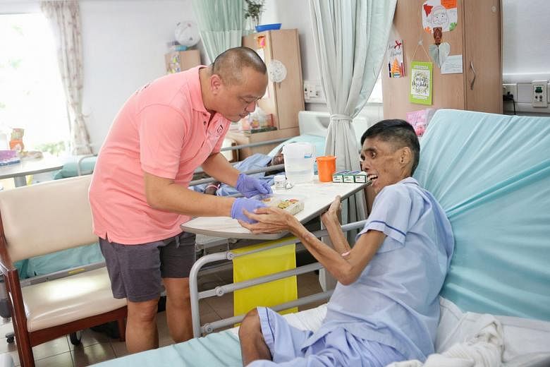 Mr Anson Ng, a 50-year-old car dealer, serving the food he prepared with the help of volunteers to Mr Yip Heng Tuck, a 54-year-old terminally ill patient at the Dover Park Hospice, last Friday. "I find it meaningful to help make each meal good in cas