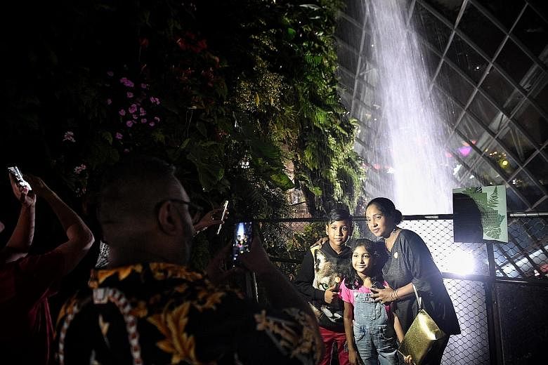 Warehouse assistant William Shawn, 41, taking a shot of his wife Maha, 47; son Jordan, 13; and daughter Levisha, nine, at Ignight @ Cloud Forest at Gardens by the Bay yesterday as they soaked in the lights and atmosphere. Another son, Ryan, 15, is no