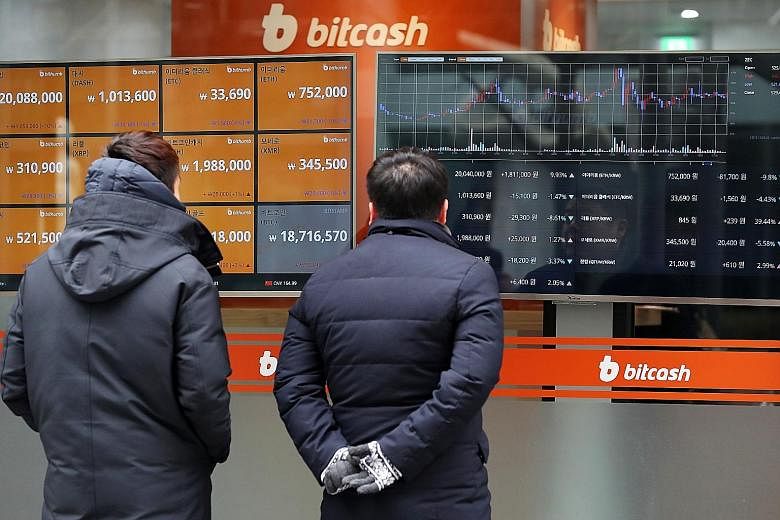 Pedestrians checking the prices of virtual currencies at the Bithumb exchange office in Seoul, South Korea, earlier this month. The South Korean authorities have said they would ban anonymous trading of virtual currencies and crack down on illicit ac