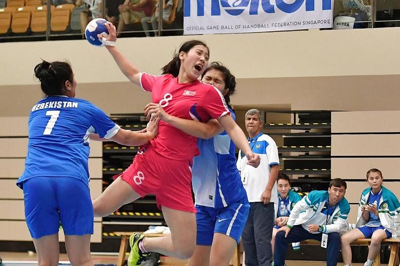 North Korea's Han Chun Yon (in red) was part of the team who beat Uzbekistan 40-25 in the women's final of the Singapore Handball Open at Our Tampines Hub yesterday. The annual Singapore Handball Open, into its fifth edition, featured 13 teams - nine