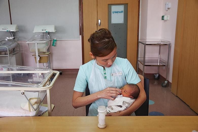 SGH nurse clinician Audrey Seet giving a baby girl, who was born on Tuesday, ready-to-feed (RTF) formula. The hospital currently uses six different RTF brands, which are offered on rotation to babies who need them.