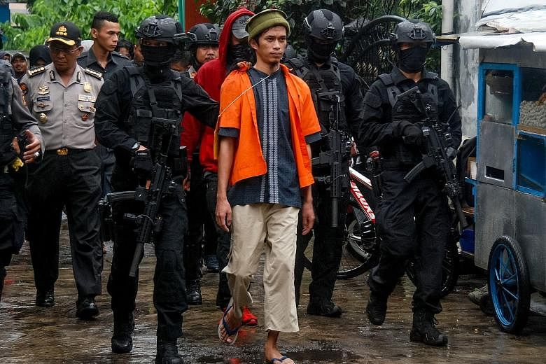 Detachment 88 anti-terror police escorting terror suspects during a reconstruction in Mekarsari in Bandung, West Java province, in October. The elite unit has won praise for the many raids it has made on militant networks in Indonesia, foiling attack