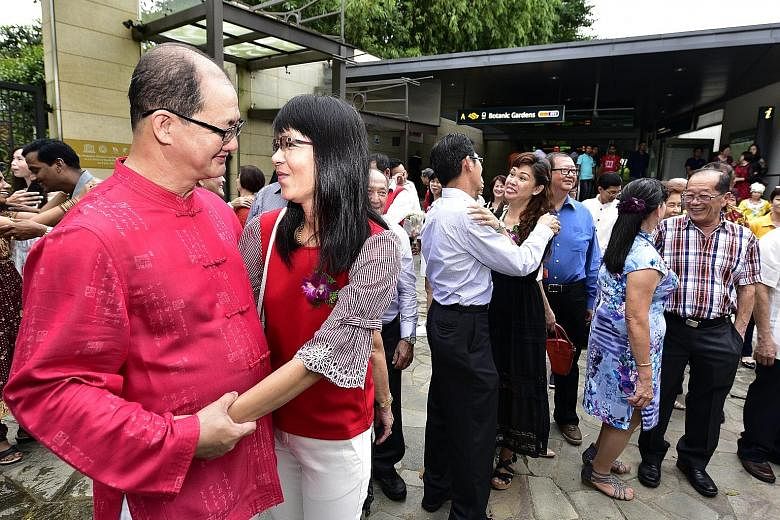 Operation Coordinator Teoh Chin Chong (left), 52 , and his wife, housewife Winnie Sia Kie Hee, 51, were among the 32 couples who reaffirmed their marriage vows outside Botanic Gardens MRT station, as part of a grassroots initiative to promote family 
