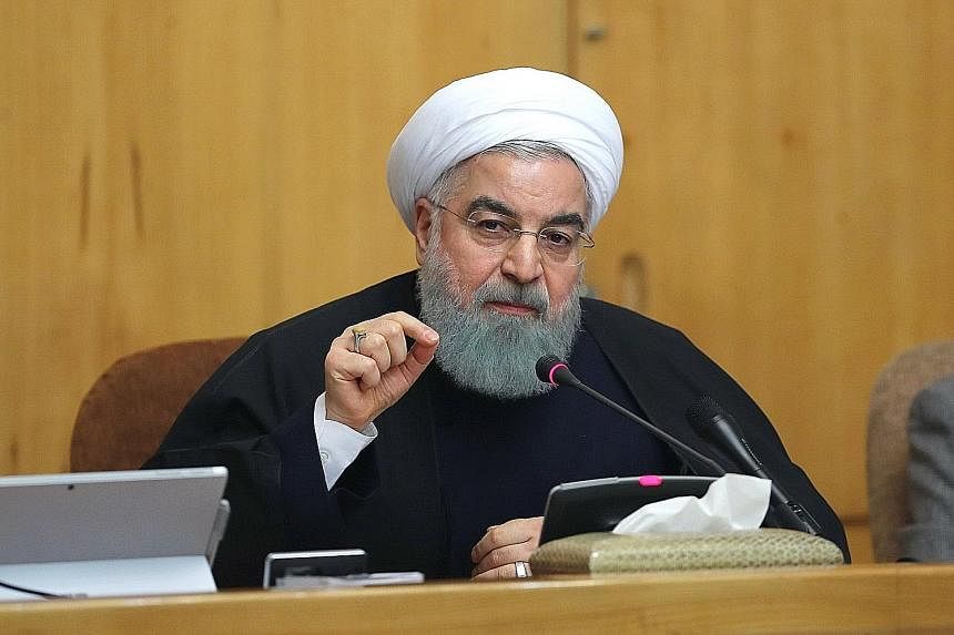 Opponents of Iranian President Hassan Rouhani protesting outside the Iranian embassy in the British capital London on Sunday. Mr Rouhani (below) has played down the unrest, saying: "This is nothing." He added that "criticism and protest are an opport