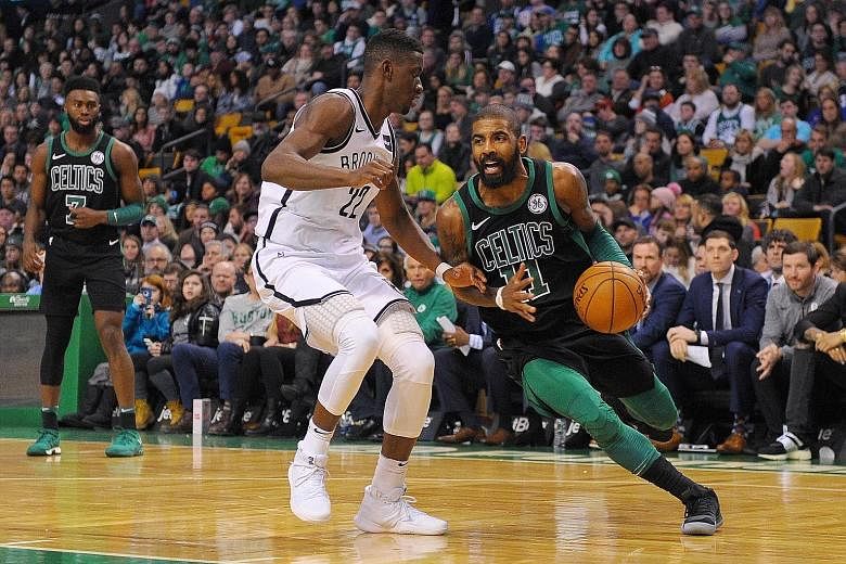 Boston Celtics point guard Kyrie Irving driving to the basket despite the attention of Brooklyn Nets guard Caris LeVert during their 108-105 win at the TD Garden on Sunday. Celtics' Irving was the outstanding player for the home team with 28 points, 