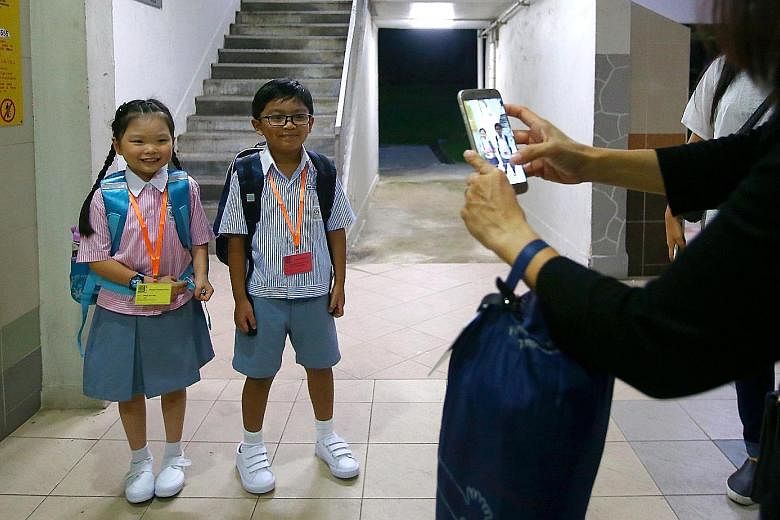 From left: Muhammad Aiman Aqmal Nor Md having breakfast before his first day at Shuqun Primary School, and then stopping for a photo with his neighbour Grace Tng. Right: Grace, too, is all set to head to school for her first day. Form teacher Lily Ye