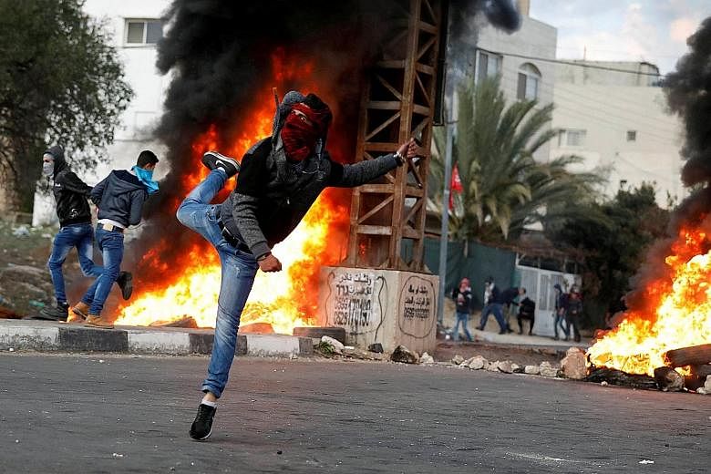 A Palestinian demonstrator hurling stones at Israeli troops during clashes at a protest near the West Bank city of Nablus last Friday against US President Donald Trump's decision to recognise Jerusalem as the capital of Israel.