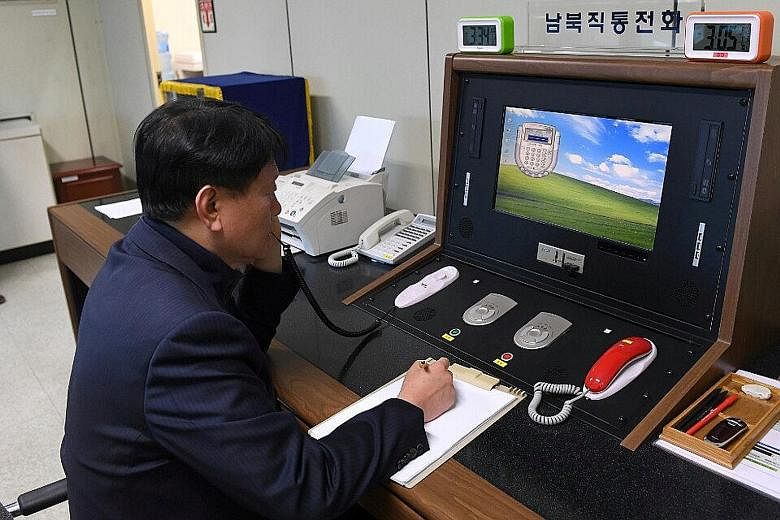 A South Korean official checking the direct communications hotline with the North Korean side at the border village of Panmunjom in South Korea yesterday. Pyongyang had suspended the hotline in February 2016 in protest against Seoul closing down the 