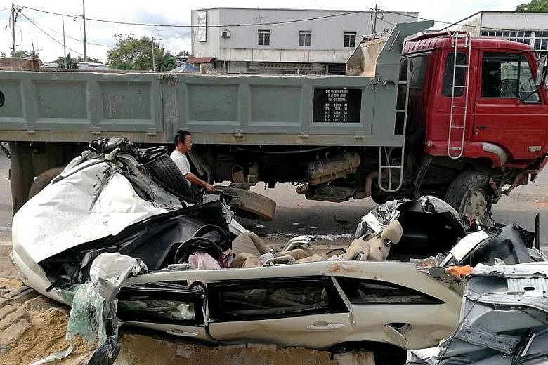 The white Honda Stream was crushed by the tipper truck, which had to be lifted using a crane to free the car.