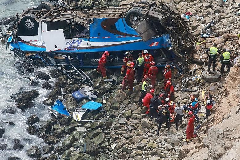 Rescue workers at the site of the crash on the Pasamayo highway. The bus was travelling to the capital Lima from the city of Huacho, about 130km north of the capital, with 55 passengers and two crew members.