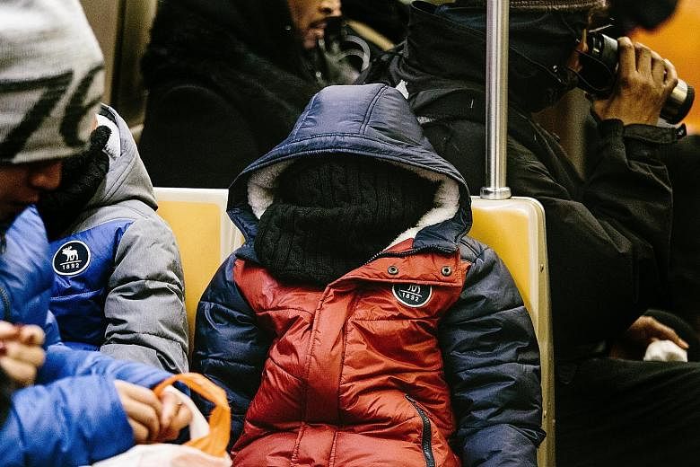 A commuter in New York all bundled up for the cold. The eastern US, now in the grip of a cold snap, will see freezing rain, snow and strong winds.