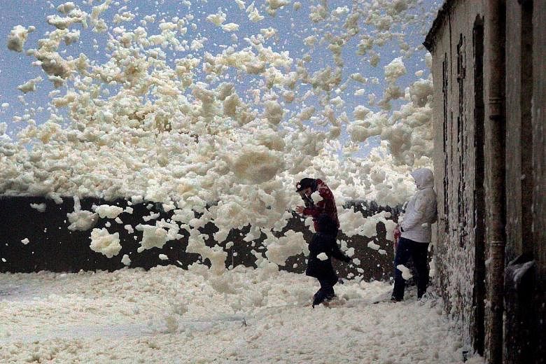 People surrounded by floating sea foam on the Brittany coast after Storm Eleanor hit Saint-Guenole in western France on Wednesday. Eleanor, the fourth winter storm to hit Europe since last month, swept into the continent on Wednesday after battering 